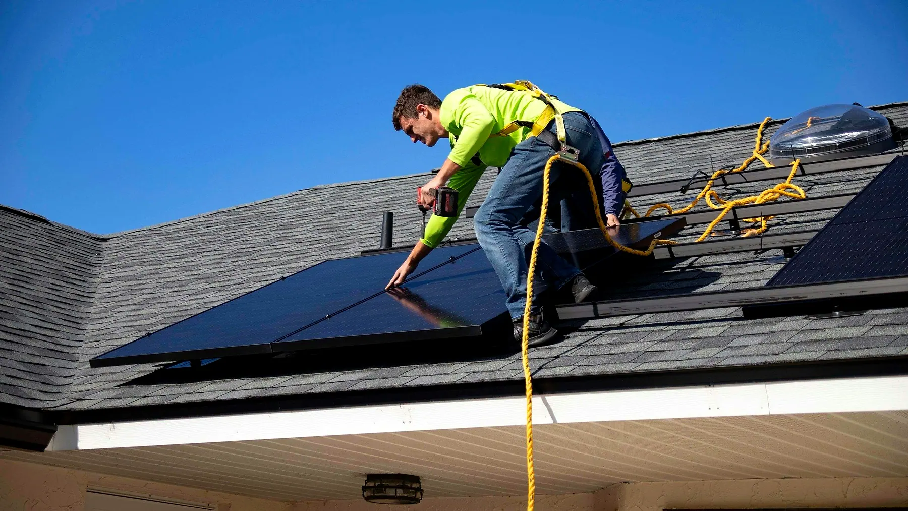 An installer fitting solar panels on a roof