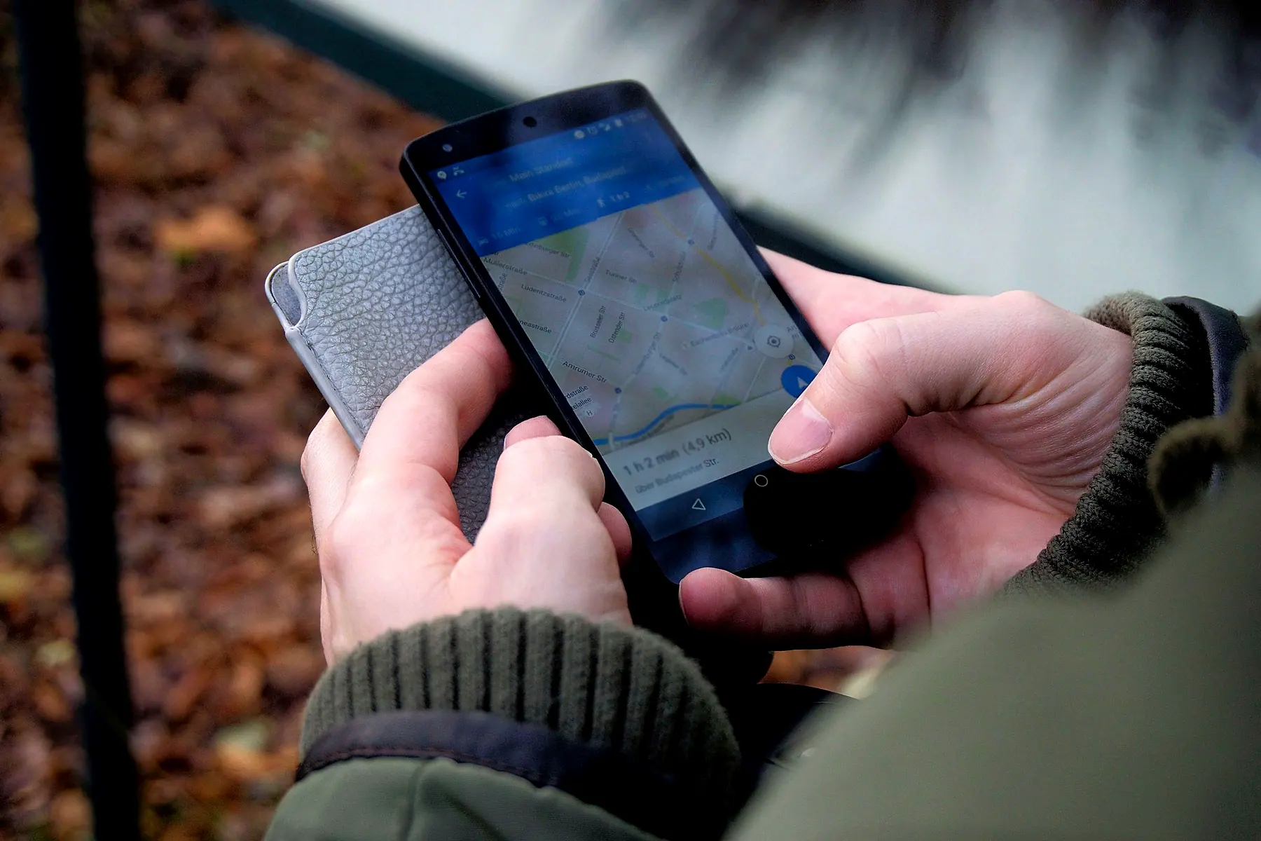 Hands holding a phone with Google Maps open on a walking route