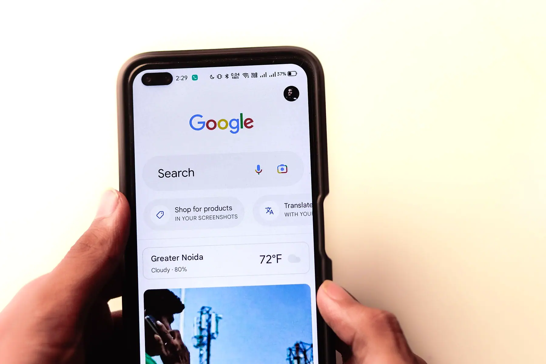 Hands holding a phone open on the Google search page