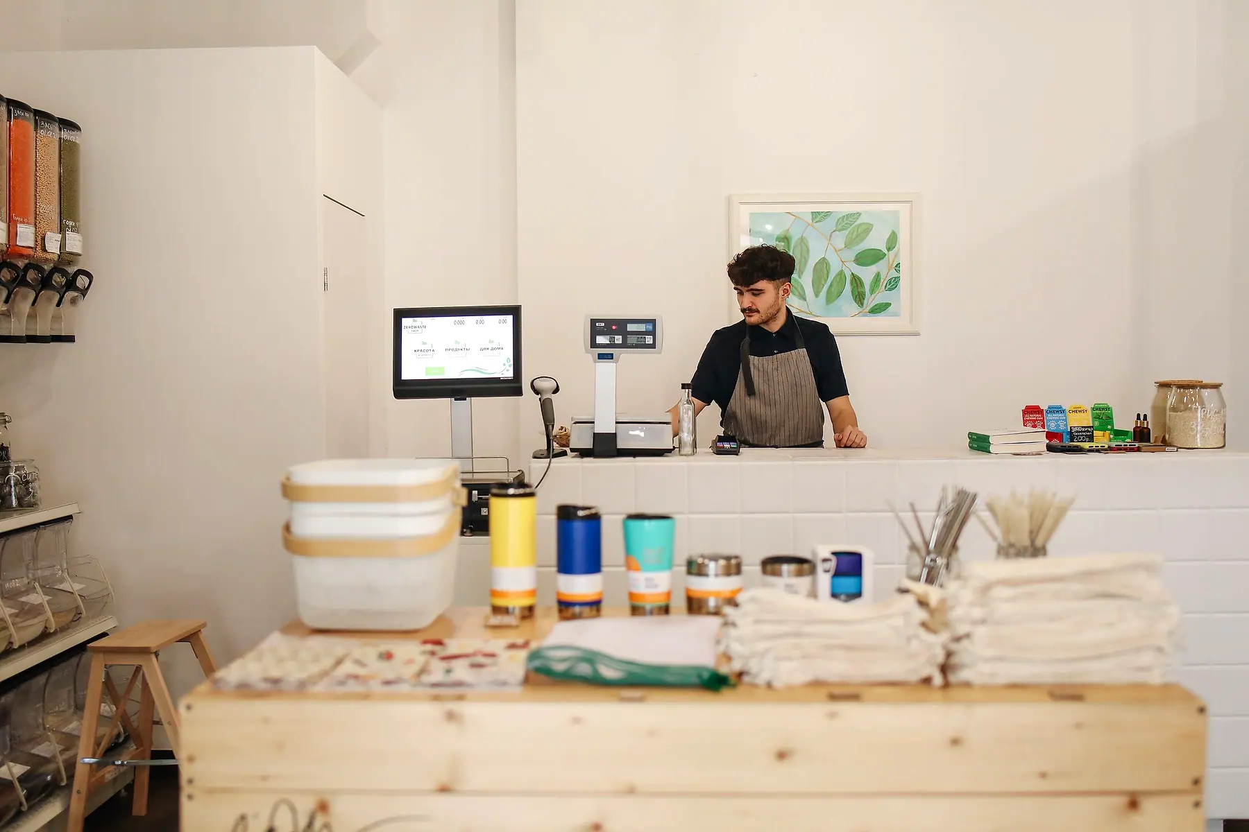 A shop owner behind the counter of a small retail store